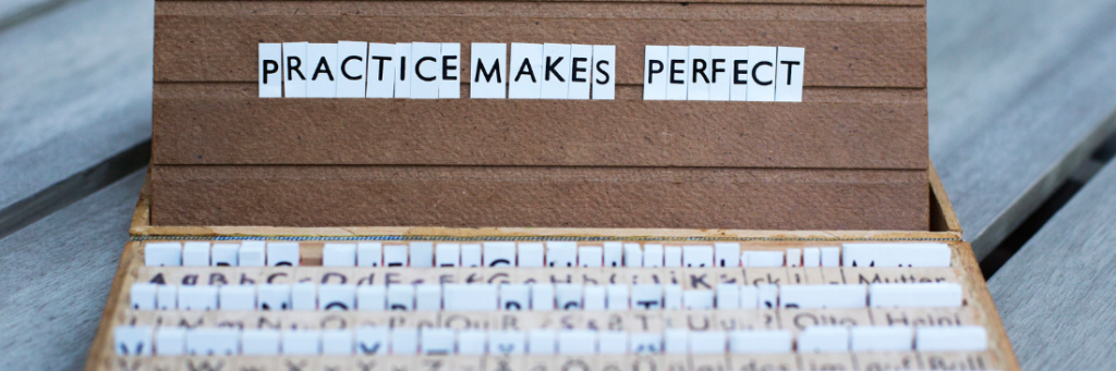 Een letterplank met de tekst ‘Practice Makes Perfect’, benadrukt dat leren een levenslang avontuur is – vol oefenen, ontdekken en steeds beter worden.
