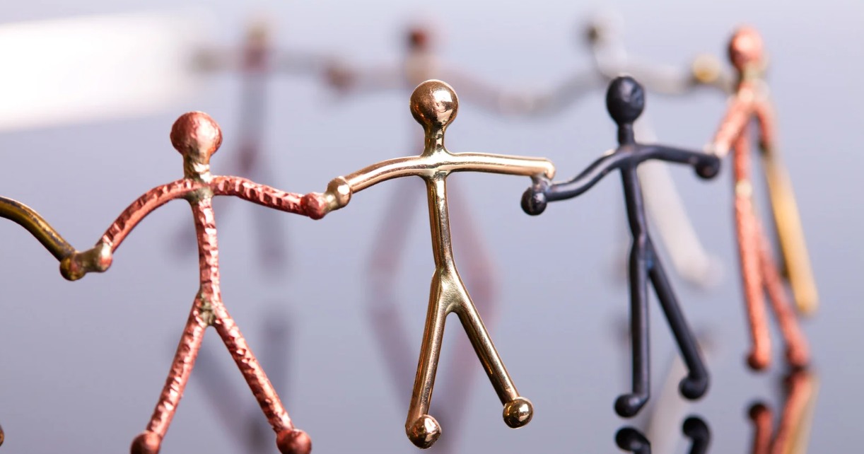 Bronzen beeldjes die elkaars handen vasthouden &ndash; symbool voor open communicatie, echte verbinding en de kracht van samenwerken